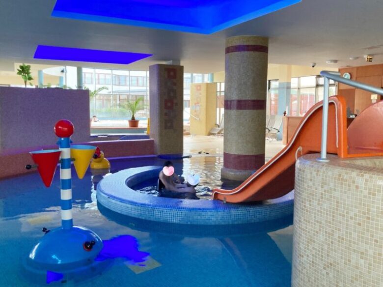 ウェルネスホテルの子供用プールで遊ぶ夫と息子