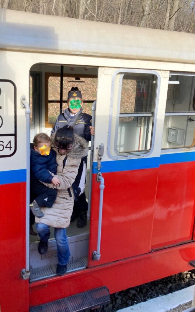 ブダペスト子供鉄道のSzépjuhászné駅で下車する親子