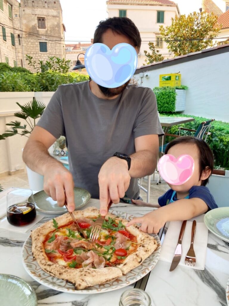 クロアチアのスプリットのレストランPizzeria Sette Sorelle　ピザを食べる夫と息子