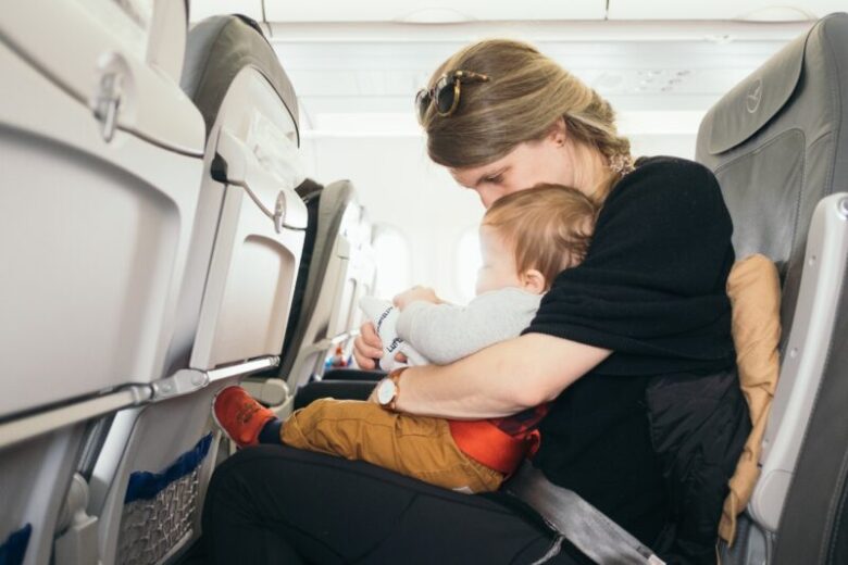 機内で席に着く母親と乳幼児