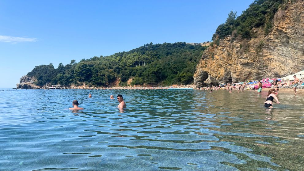 モンテネグロの人気観光地、ブドヴァにあるモグレンビーチで泳いだり遊んだりする人々