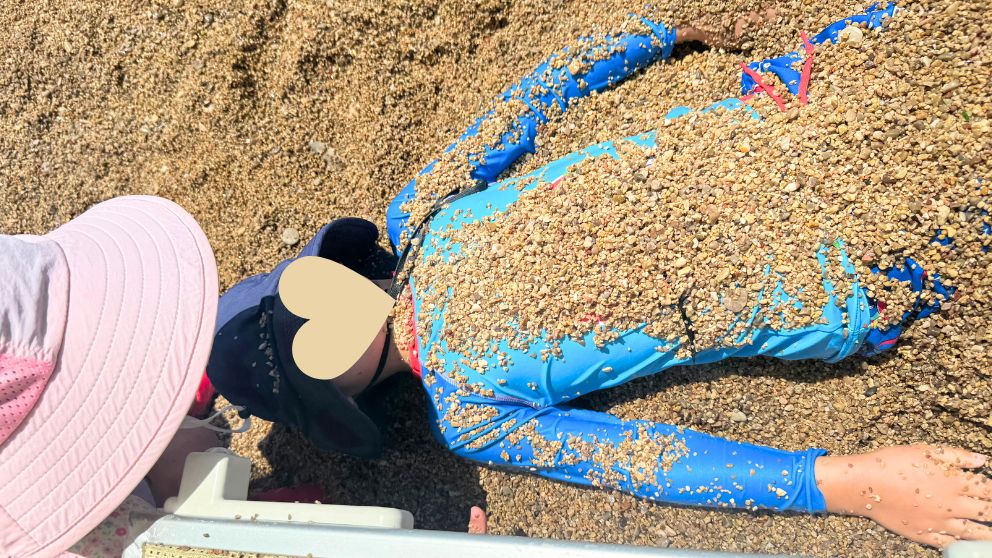 モンテネグロの人気観光地、ブドヴァにあるモグレンビーチで砂利に埋もれて遊ぶ息子