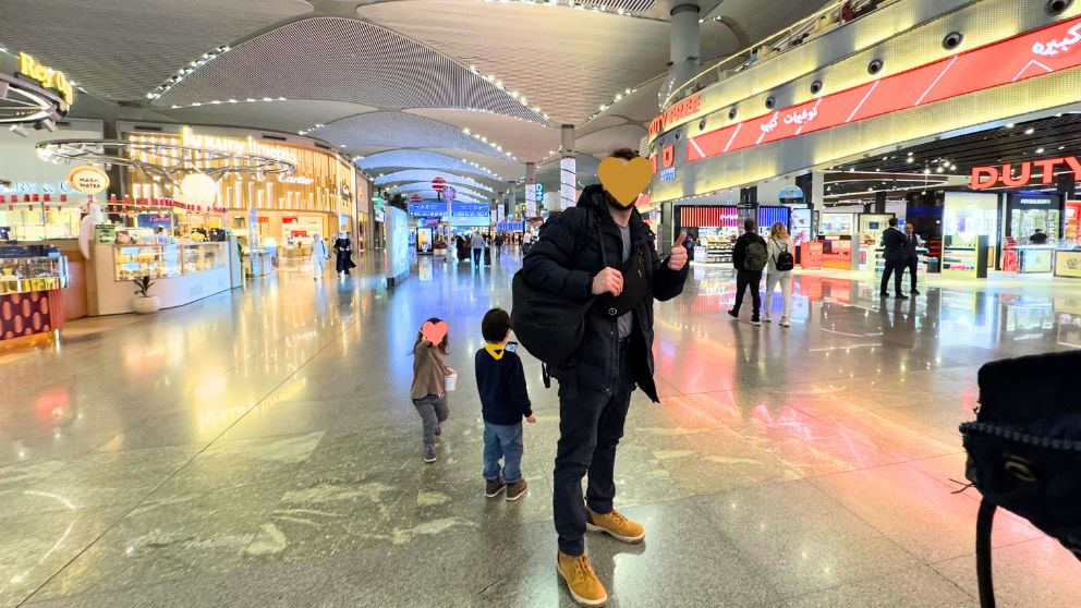 トルコのイスタンブール空港の免税買い物エリアを歩く家族