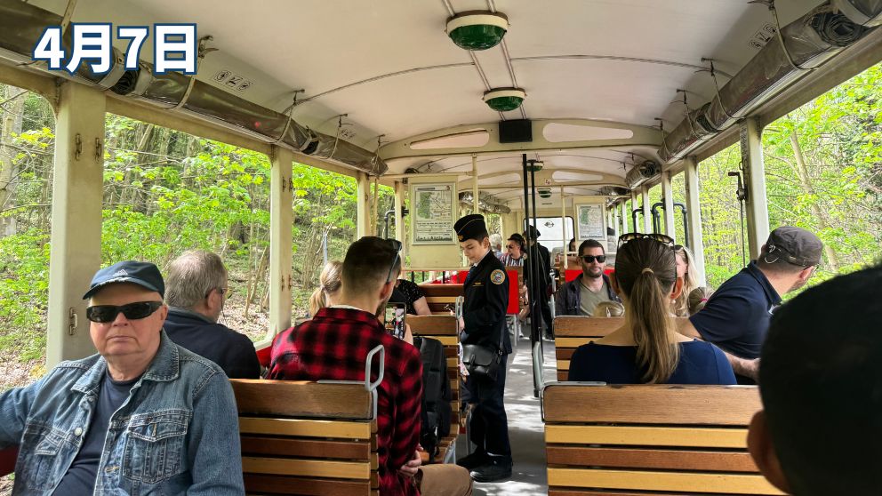 ブダペストの子供鉄道内で、チケットの検札をする子供鉄道スタッフと、新緑の風景