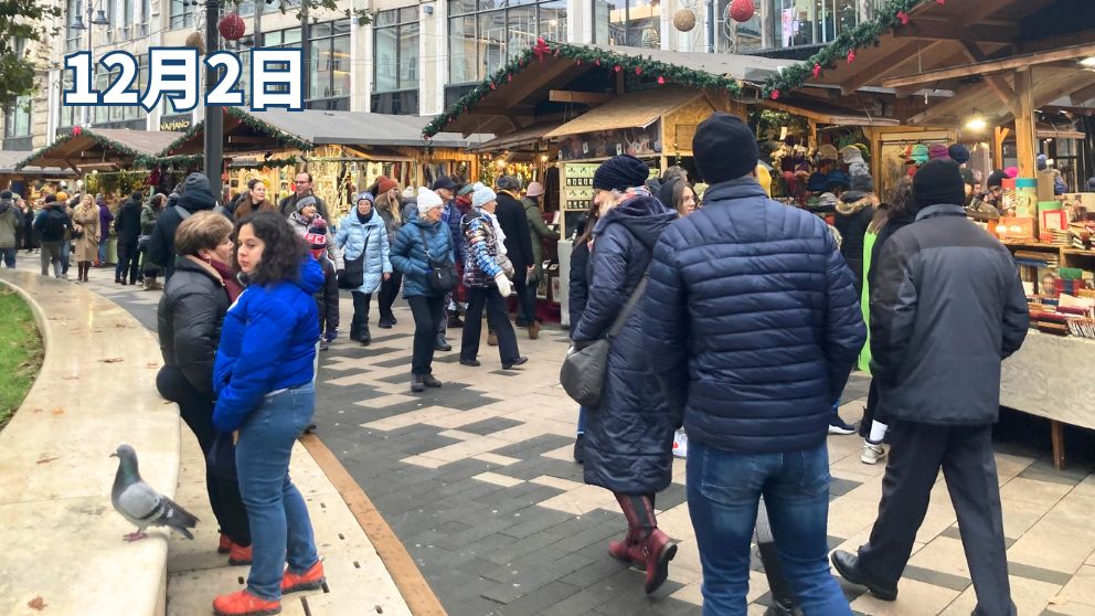 ブダペストのVorosmarty広場に並ぶクリスマスマーケットの屋台と、それを見て回る人々。長いコートに、帽子をしっかりかぶっている人が多い