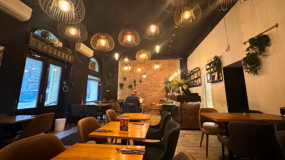ブダペスト7区にあるコーシャレストランCafe Tamarの洗練された店内。黒と白の壁に、茶色いテーブル、押さえた色合いのおしゃれな椅子