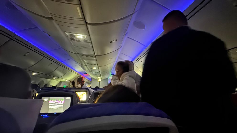 中国南方航空の機内で、グループになっておしゃべりするヨーロッパ系のお客さんたち