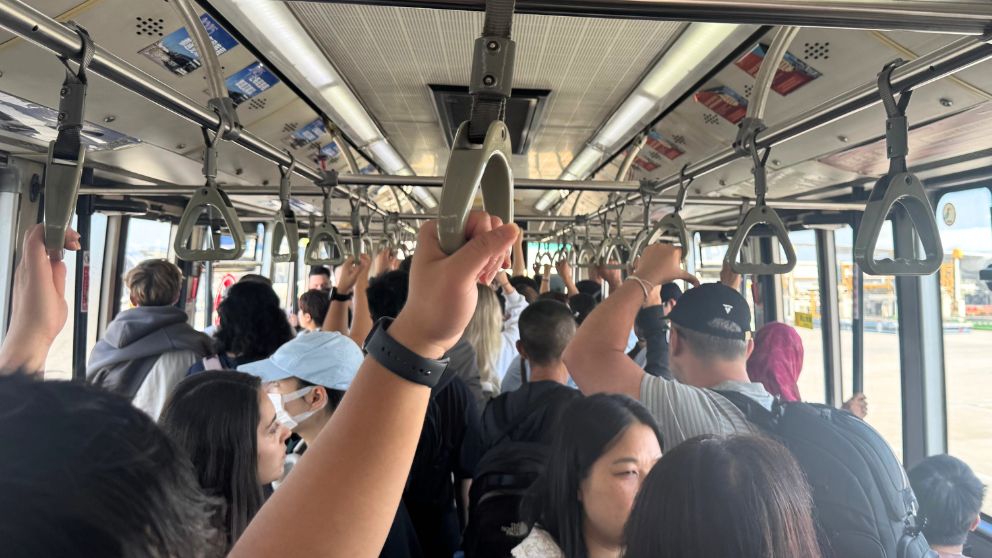 広州〜羽田行きのフライトに搭乗するため、バスで移動する人々