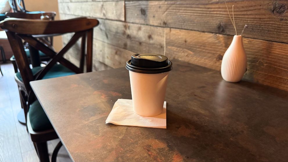 ブダペストのMiniPig Cafeのカフェのテーブルとテイクアウトコーヒー