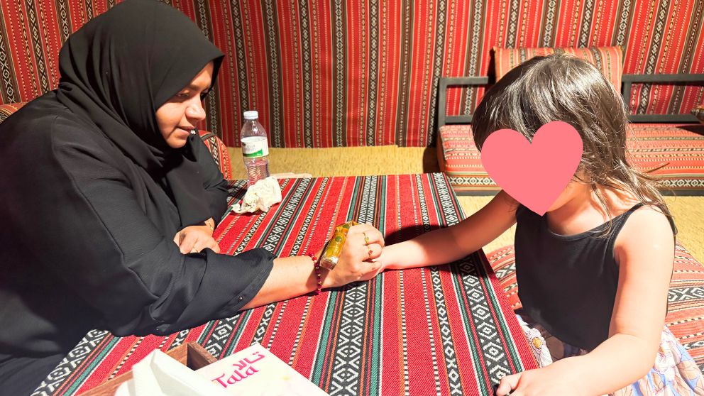 アブダビの砂漠ツアーのデザートキャンプで、ヘナタトゥーを右手に描いてもらっている娘