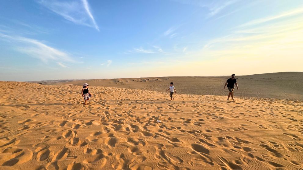 アブダビの砂漠ツアーのフォトストップで砂漠を歩く私の家族