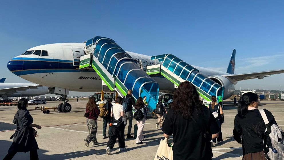 広州空港で中国南方航空の機体に乗り込む人々