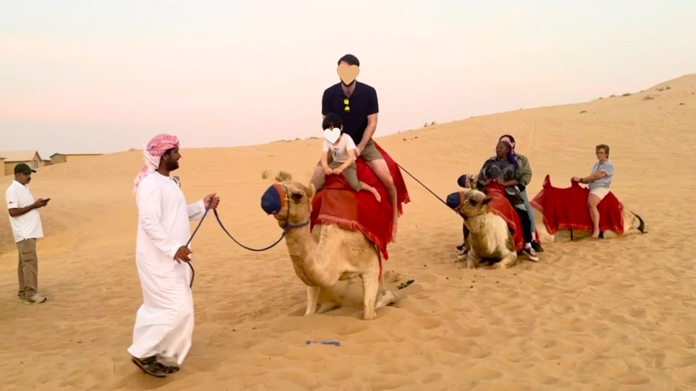 アブダビの砂漠ツアーのデザートキャンプでラクダが立ち上がる瞬間の息子と夫の様子