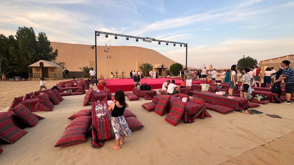 アブダビの砂漠ツアーのデザートキャンプのステージと、それを囲むテーブル席