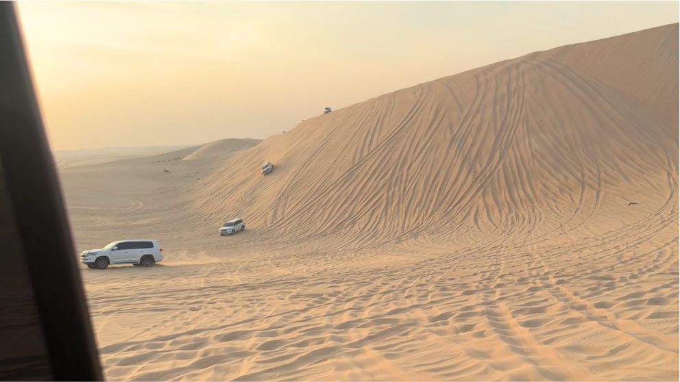 アブダビの砂漠ツアーのデューンバッシング。砂丘を滑り降りる車の様子