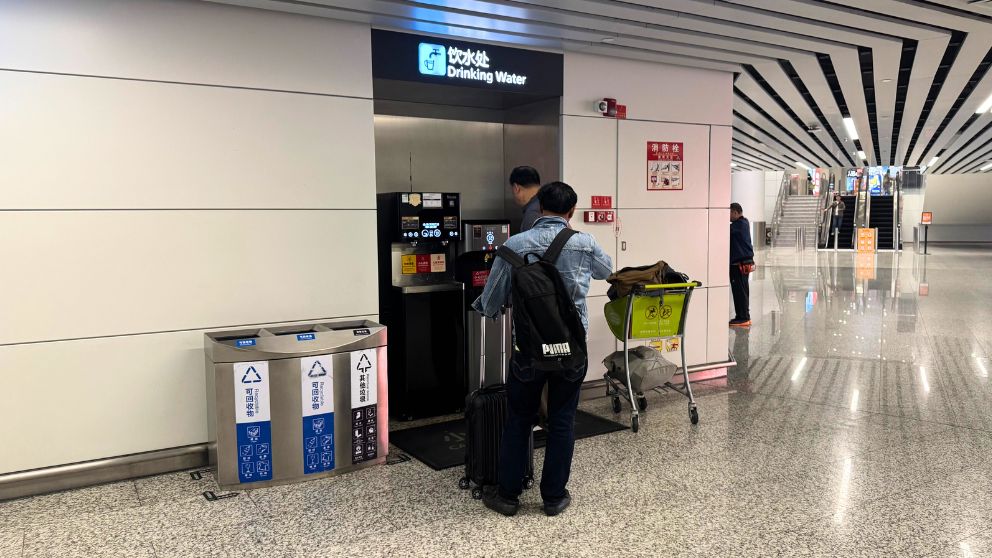 広州空港に設置されているウォーターサーバーと水を補給する人