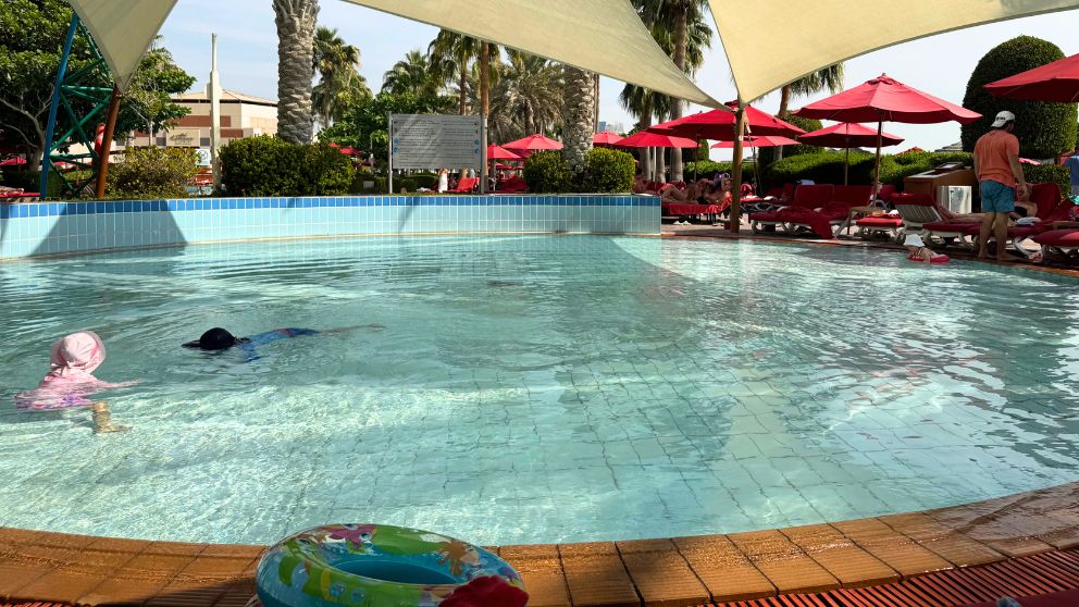 アブダビにあるホテルKhalidiya Palace Rayhaanの子ども用プールで泳ぐ息子と娘