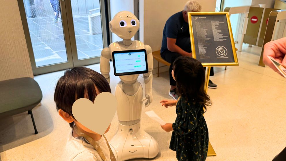 ハンガリー貨幣博物館の入り口に立っているペッパー君を眺める息子と娘