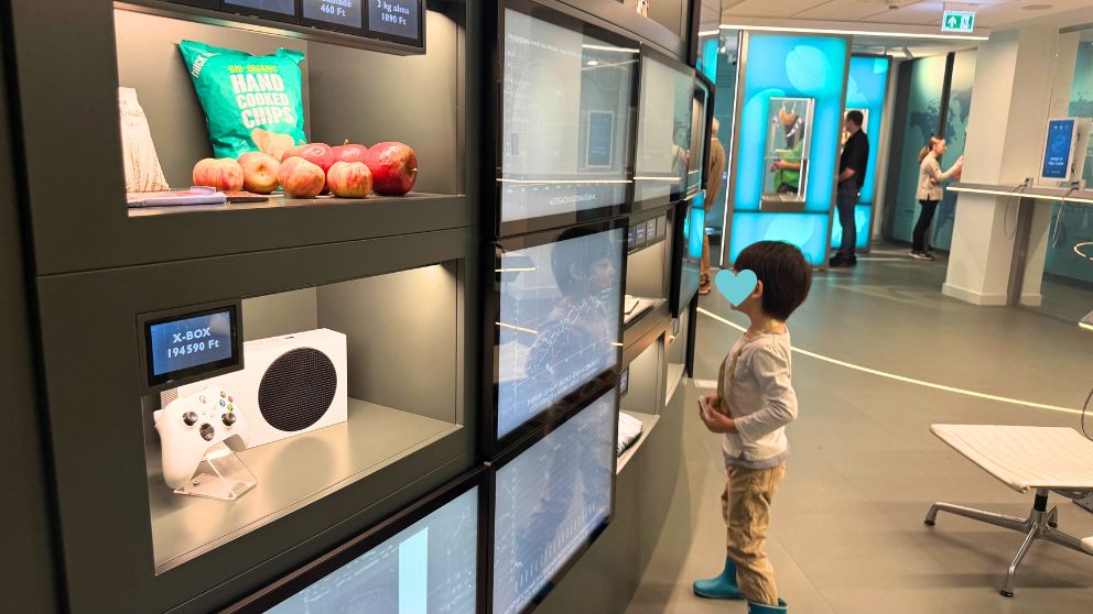 ハンガリー貨幣博物館のお金の価値に関する展示を眺める息子