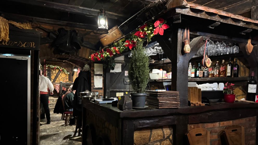 レストランの店内。少し薄暗くて、色の濃い木のカウンターがある