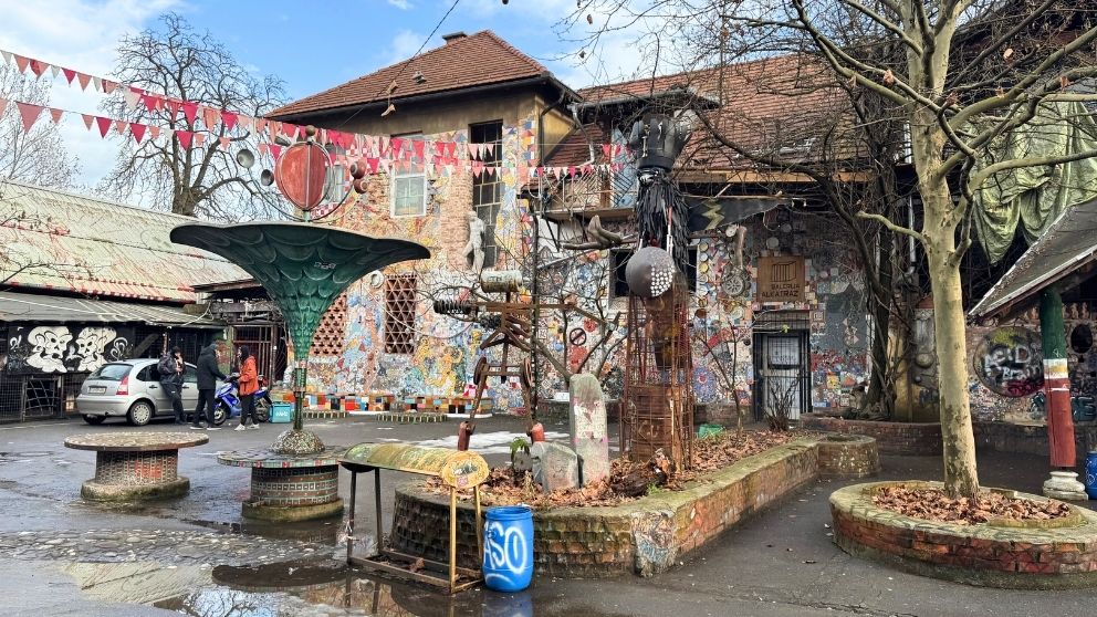 メテルコバ地区のペイントされた建物、不思議な彫刻が並ぶ中庭の様子