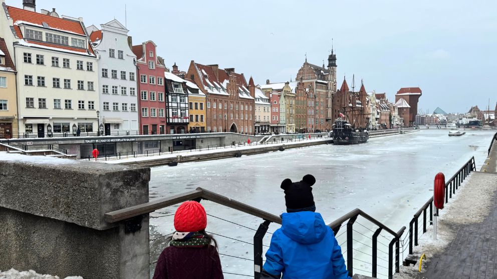 凍っているモトワヴァ川を眺める息子と娘。遠くに海賊船のようなブラックパール号が見えている
