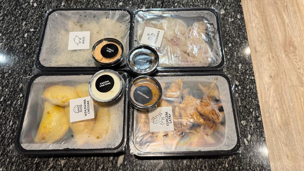 グダニスクにある「Pierogarnia Mandu」というピエロギ専門店の4種類のピエロギをテイクアウトした様子。黒い箱にそれぞれ商品が入り、付け合わせのソースの箱もついている