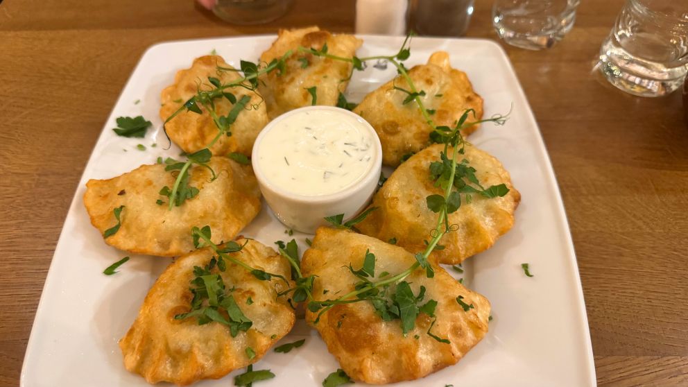 ポーランドのグダニスクにあるRybakowkaというレストランでオーダーしたサーモンとほうれん草のピエロギ7つ。中央にマヨネーズのような白いソース