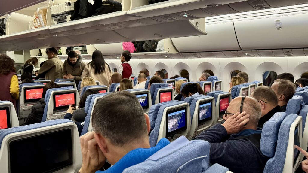 中国国際航空エコノミークラスの機内、搭乗中の乗客と「WELCOME ABOARD」と表示された赤いシートモニター