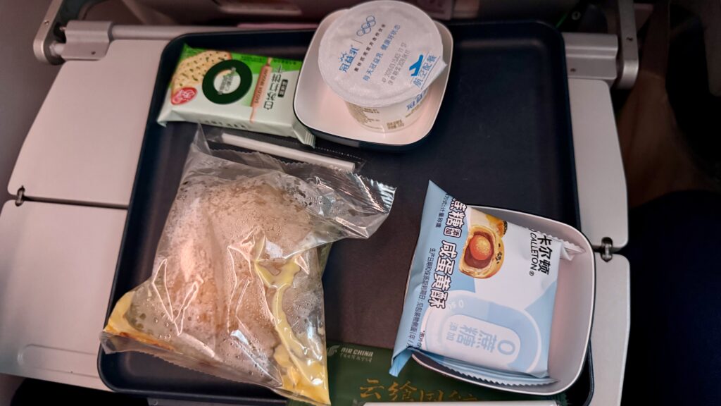 中国国際航空の機内軽食、袋入りサンドイッチ・エッグタルト・ヨーグルトのセット
