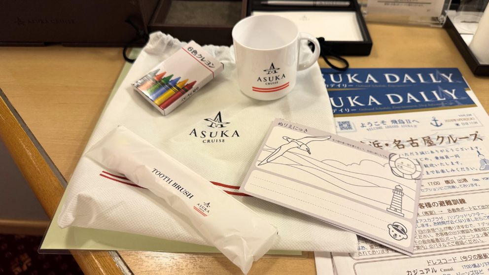 子供向けに用意された飛鳥Ⅱの可愛いアメニティ。船のイラスト入りの巾着袋や、飛鳥Ⅱオリジナルキャラクターのグッズ、子供用のスリッパなどが並んでいる