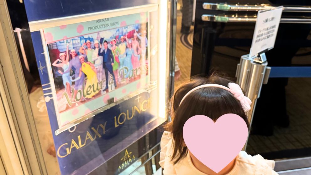 飛鳥Ⅱのイリュージョンマジックショーのポスターと、それを眺める娘