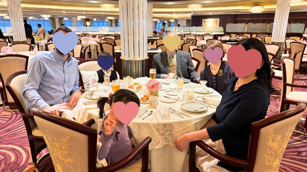 飛鳥Ⅱのディナータイムのテーブルの様子。白いテーブルクロスのかけられたテーブルには花も飾られていて優雅