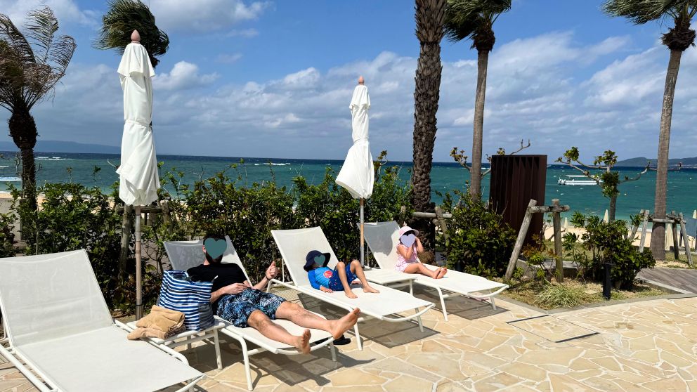 フサキビーチリゾートのビーチサイドプールのチェアに寝そべる家族