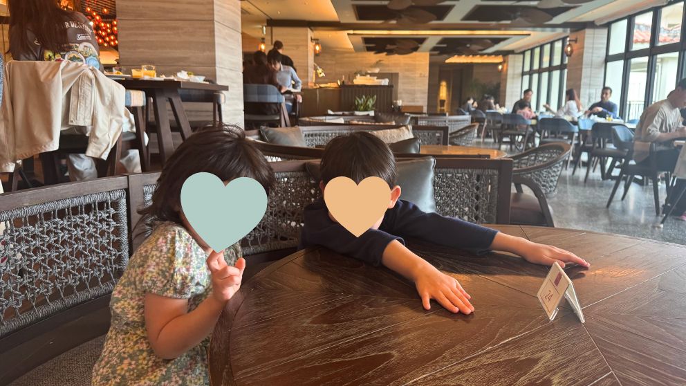 フサキビーチリゾートのIshigaki Bold Kitchenレストランで、丸いテーブル席につく息子と娘