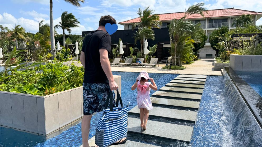 フサキビーチリゾートのビーチサイドプールの飛び石を歩く親子の後ろ姿