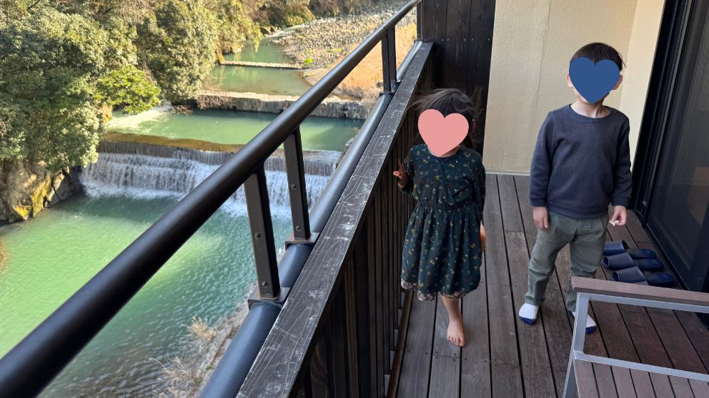 箱根水明荘の客室ベランダから見える川と子どもたちの様子