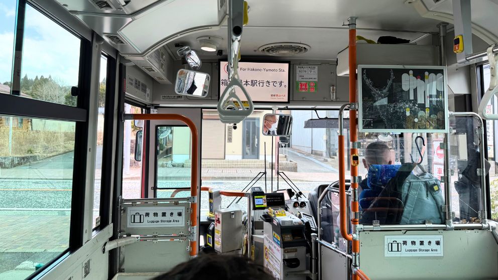 箱根登山バスの車内の様子。前方の運賃表示モニターや、箱根町港バスターミナルの様子