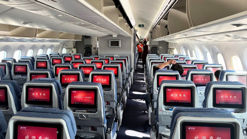 中国国際航空エコノミークラスの機内。赤い搭乗歓迎画面が映し出された個人モニターが並ぶ
