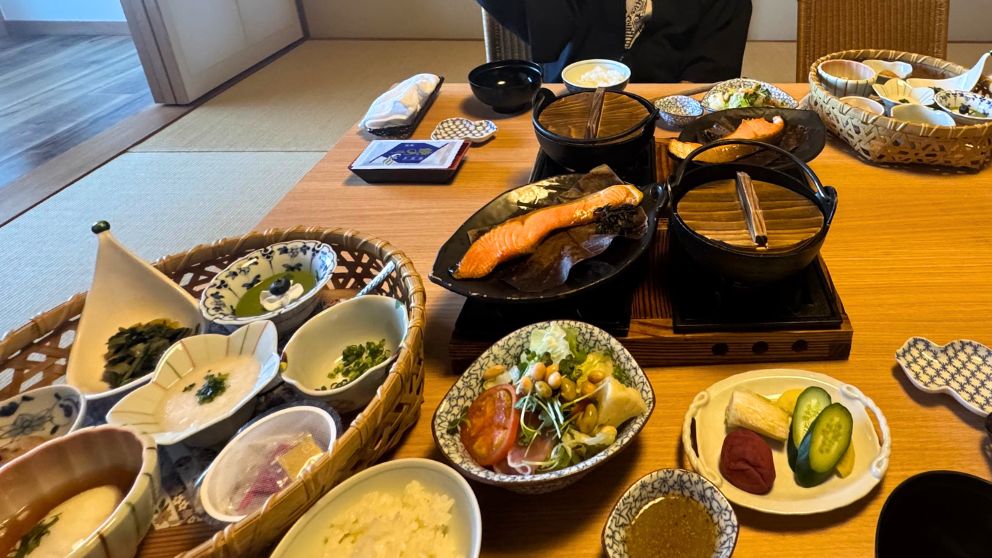 千明仁泉亭の朝食。焼き鮭や小鉢など品数豊富な和朝食が並ぶ