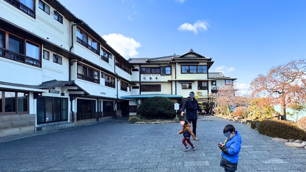 千明仁泉亭の外観。歴史ある建物の前で遊ぶ子どもたちの様子