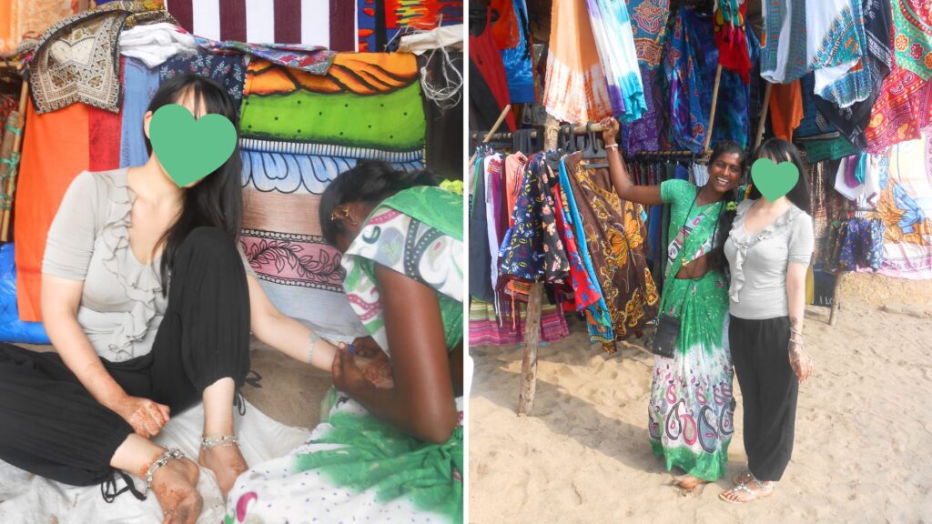 ゴアのビーチでヘナタトゥーを施す地元女性と、カラフルな布製品を売るビーチ売り子