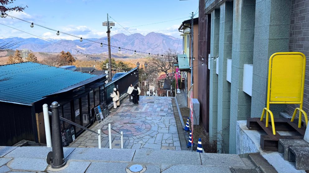 伊香保温泉の石段街の様子。山並みを背景に風情ある温泉街が広がる