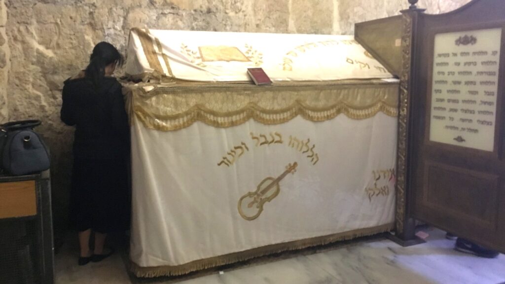 シオン山にあるダビデ王の墓(ケノータフ)。刺繍が施されたビロードの布で覆われた記念碑の前で祈る女性