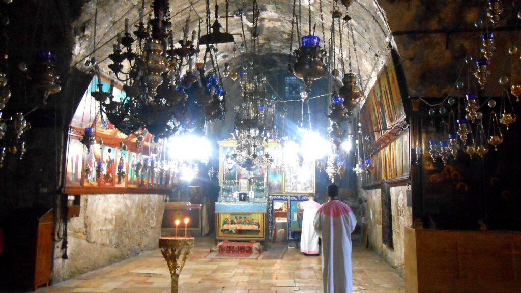 聖母マリアの墓教会の内部。薄暗い地下空間にランプやイコンが並ぶ荘厳な雰囲気