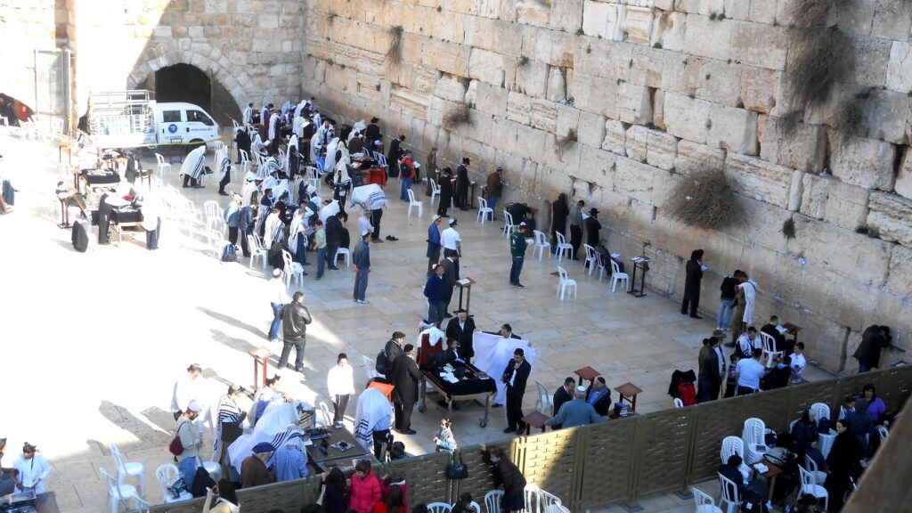 エルサレム旧市街の嘆きの壁(西の壁)。白いタリットをまとったユダヤ教の信者たちが祈りを捧げている