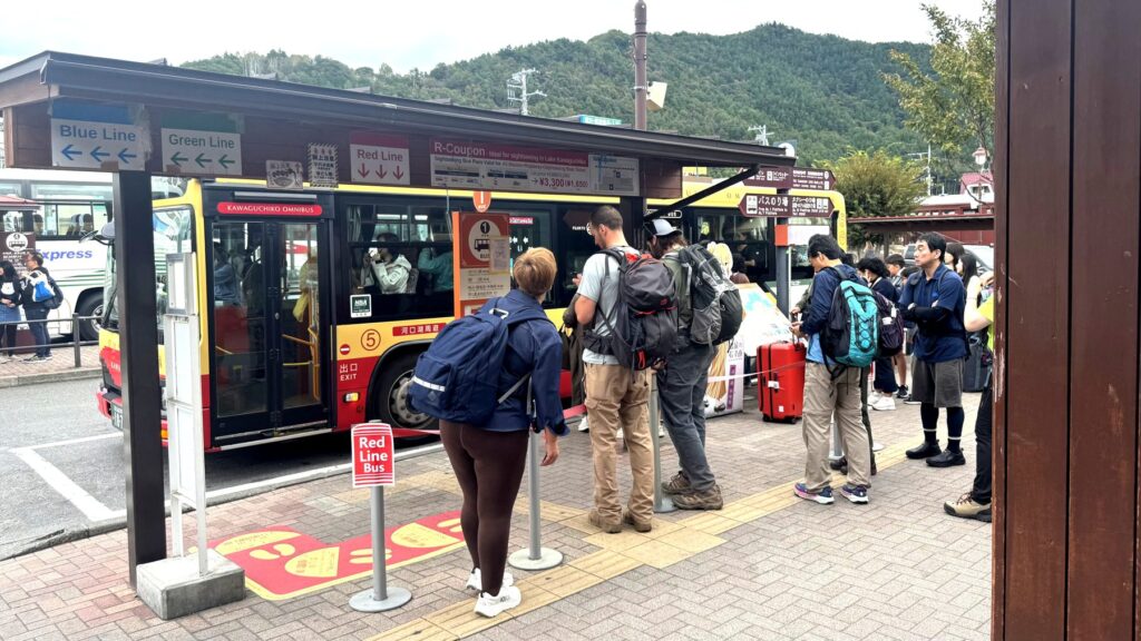 河口湖駅前のレッドラインバス乗り場と観光客