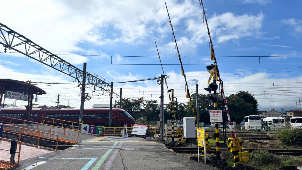 河口湖駅の踏切と線路、奥に赤い電車