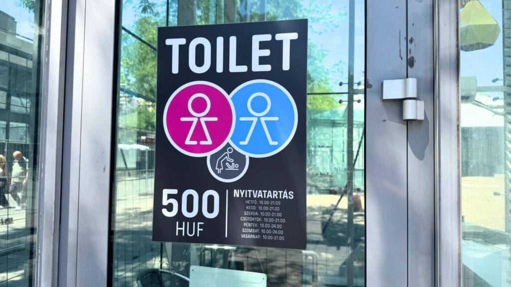 ブダペストの有料トイレの案内表示。料金は500フォリントで、営業時間が記載されている。