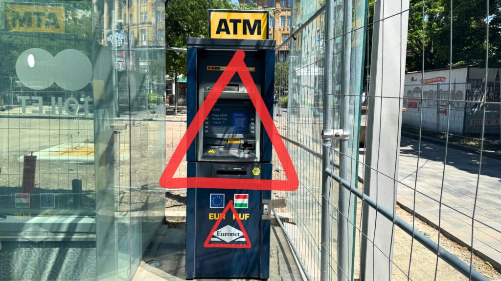 ブダペストの路上にあるユーロネット(Euronet)の青いATM。手数料が高くレートも悪いため、注意を促す赤い警告マークを重ねている